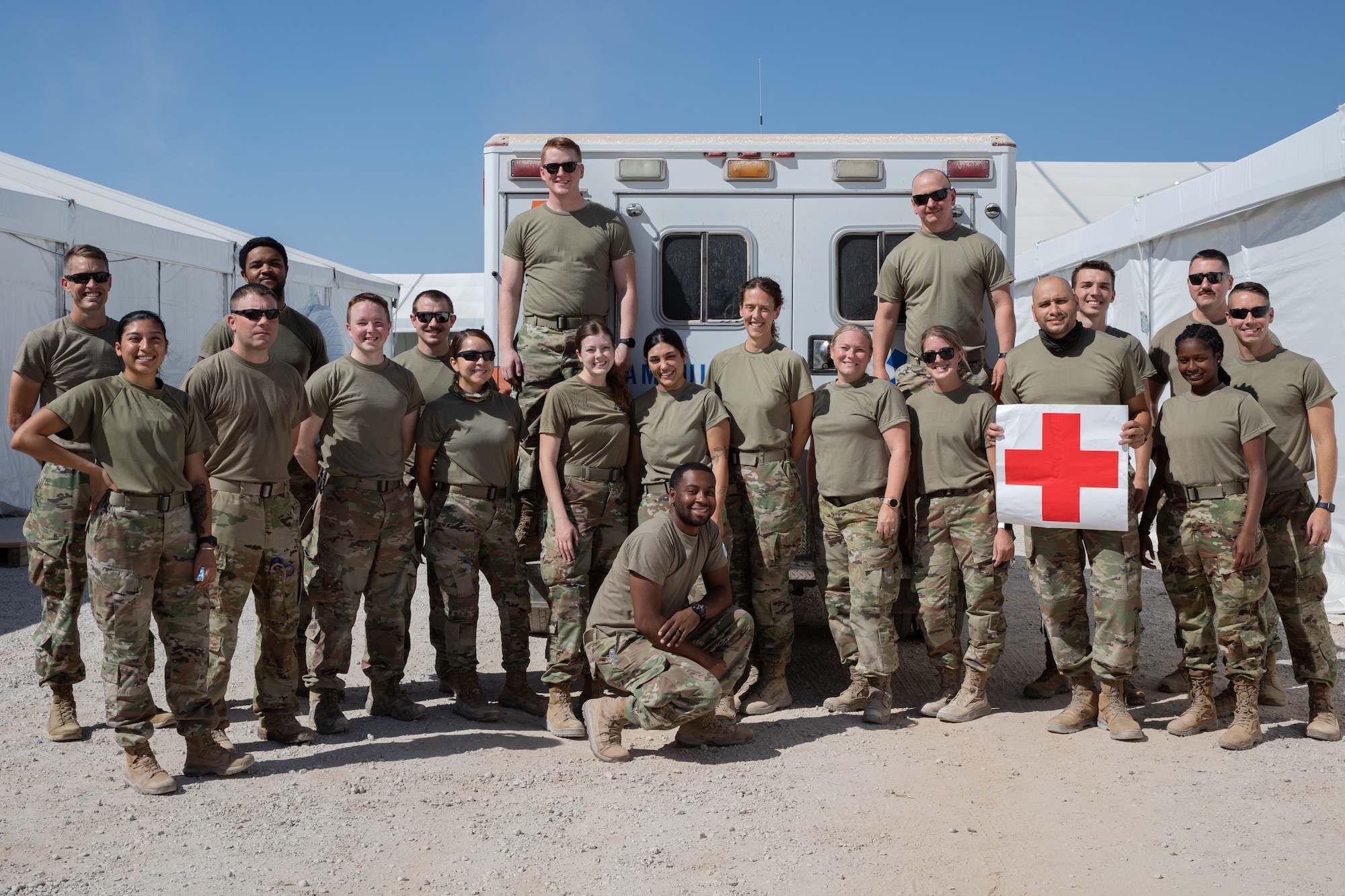 Airmen from the Task Force-Holloman triage facility medical team pose for a group photo at Aman Omid Village on Holloman Air Force Base, New Mexico, Sept. 22, 2021. The Department of Defense, through the U.S. Northern Command, and in support of the Department of State and Department of Homeland Security, is providing transportation, temporary housing, medical screening, and general support for at least 50,000 Afghan evacuees at suitable facilities, in permanent or temporary structures, as quickly as possible. This initiative provides Afghan evacuees essential support at secure locations outside Afghanistan. (U.S. Army photo by Spc. Nicholas Goodman)