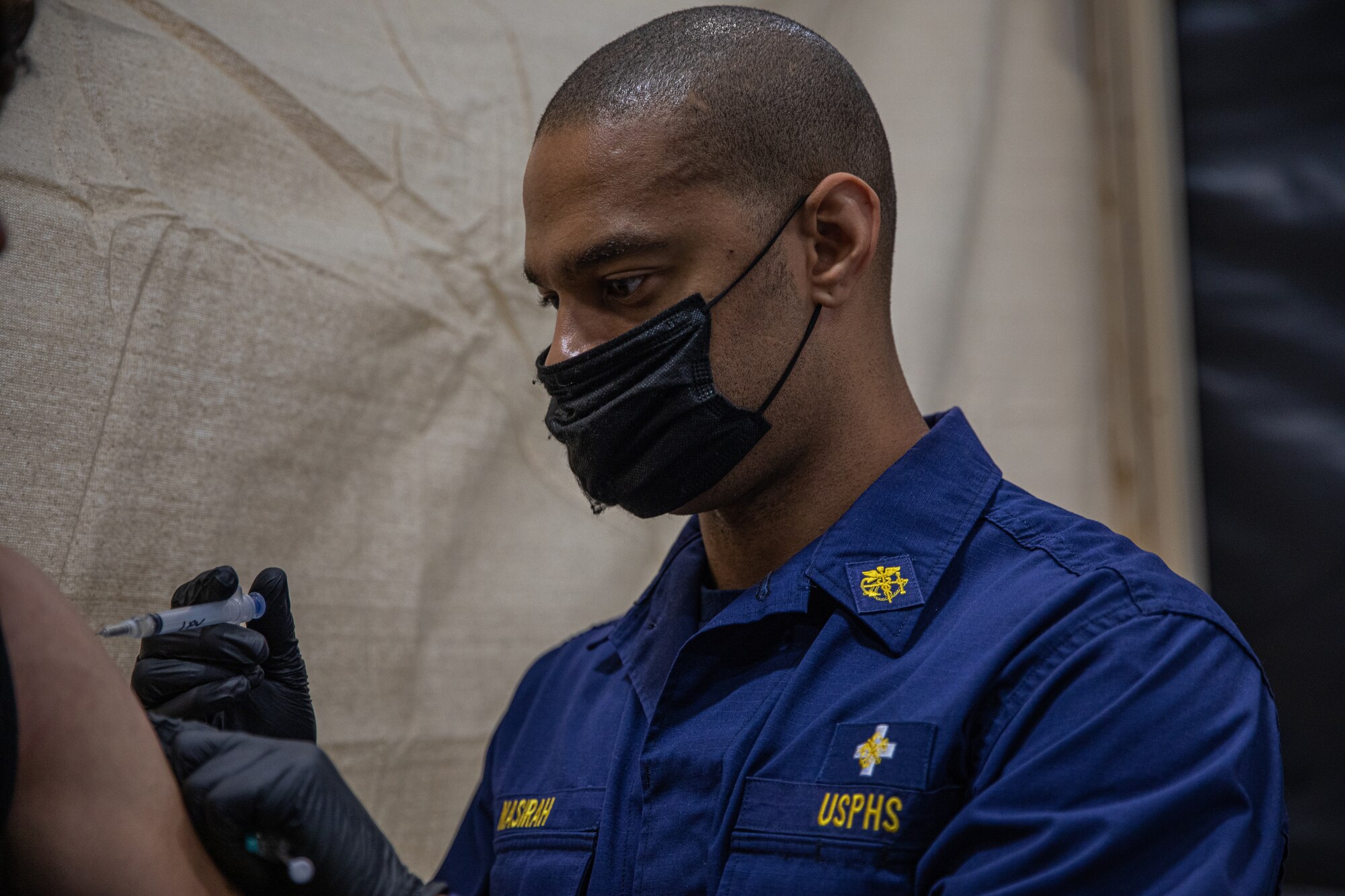 Personnel from the United States Public Health and Services Commissioned Corps, attached to Task Force-Holloman, provide Afghan evacuees with vaccinations on Holloman Air Force Base, New Mexico Sept. 26, 2021. The Department of Defense, through U.S. Northern Command, and in support of the Department of State and Department of Homeland Security, is providing transportation, temporary housing, medical screening, and general support for more than 50,000 Afghan evacuees at suitable facilities, in permanent or temporary structures, as quickly as possible. This initiative provides Afghan evacuees essential support at secure locations outside Afghanistan. (U.S. Army photo by Pfc. Anthony Sanchez)