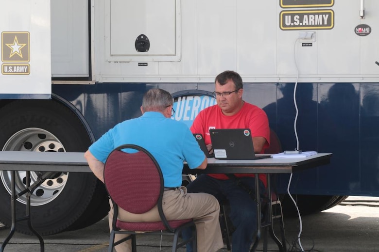 David Landis, a park ranger from the Nashville District is assigned to the Deployable Tactical Operations System, or DTOS that is being used as a Right of Entry (ROE) collection site for the Hurricane Ida Blue Roof program at the Houma-Terrebonne Civic Center in Houma, Louisiana . USACE is supporting the state of Louisiana under a FEMA mission assignment to assist eligible homeowners with temporary roof repairs through the Operation Blue Roof program. Landis is providing help to a homeowner with the completion of his on-line ROE. The DTOS provides mobile communications and operations workspace to support emergency response missions. (U.S. Army photo by Brooks O. Hubbard, U.S. Army Corps of Engineers)