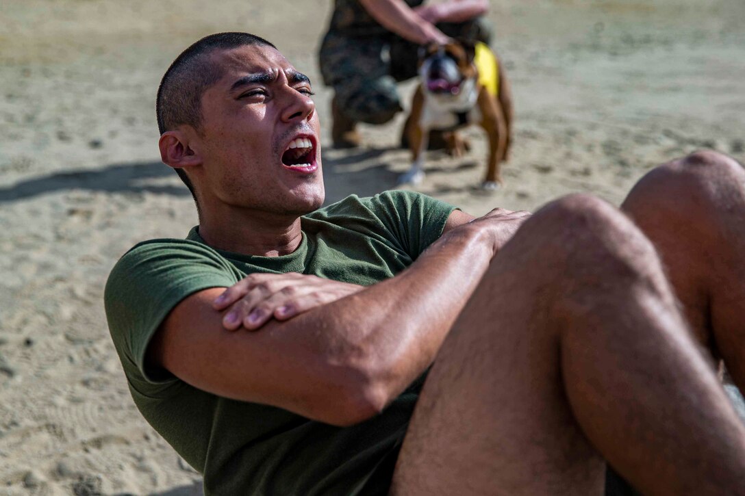 A Marine Corps recruit performs a crunch.