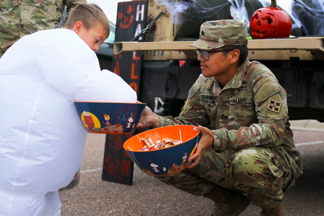 A soldier hands out candy to a child.