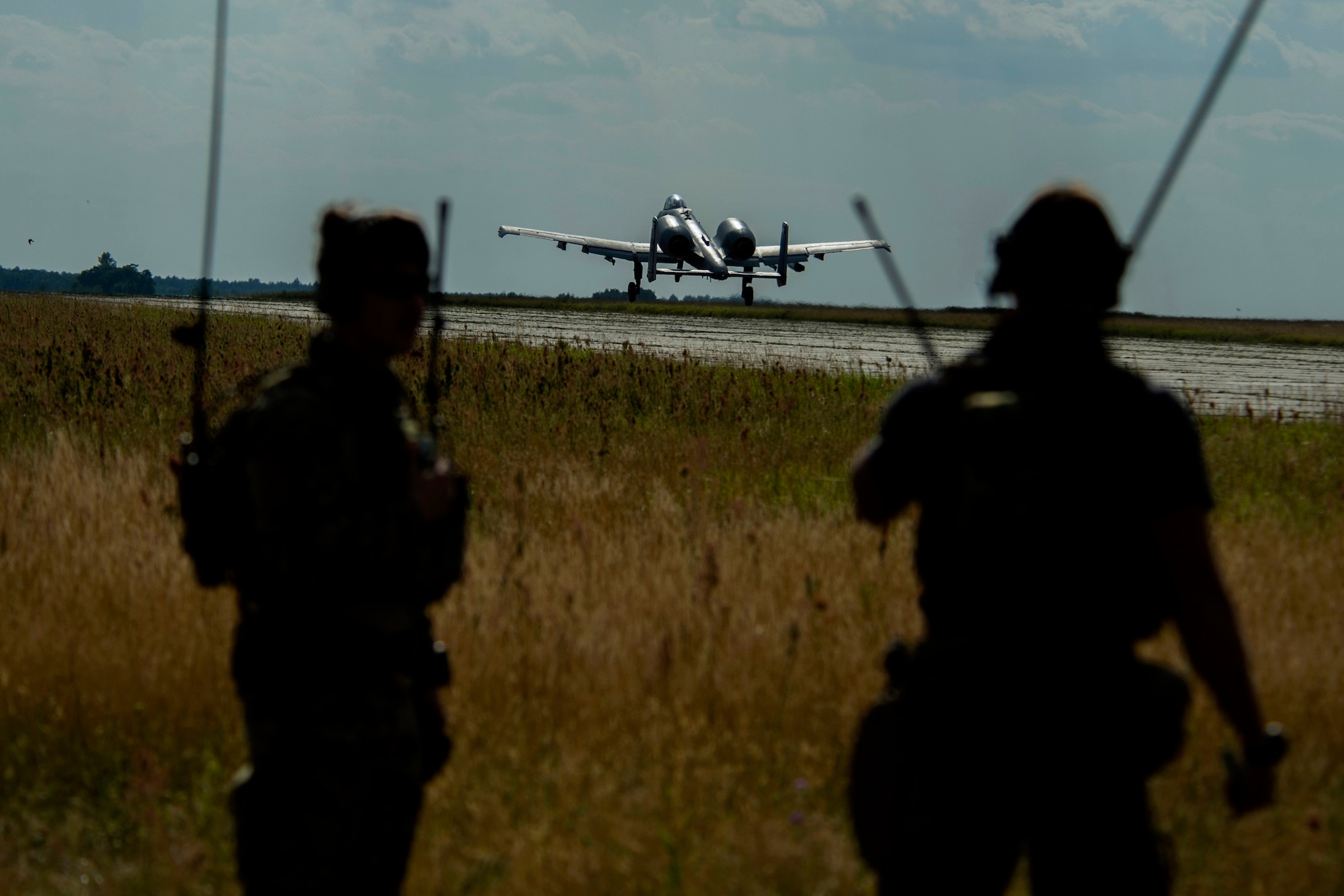 A 354th Expeditionary Fighter Squadron A-10C Thunderbolt II aircraft takes off in front of two 321st Special Tactics Squadron combat controllers during an austere landing training exercise at Nowe Miasto, Poland, July 20, 2015. The 321st STS combat controllers ground air traffic control for the A-10 pilots during the exercise. (U.S. Air Force photo by Airman 1st Class Luke Kitterman)