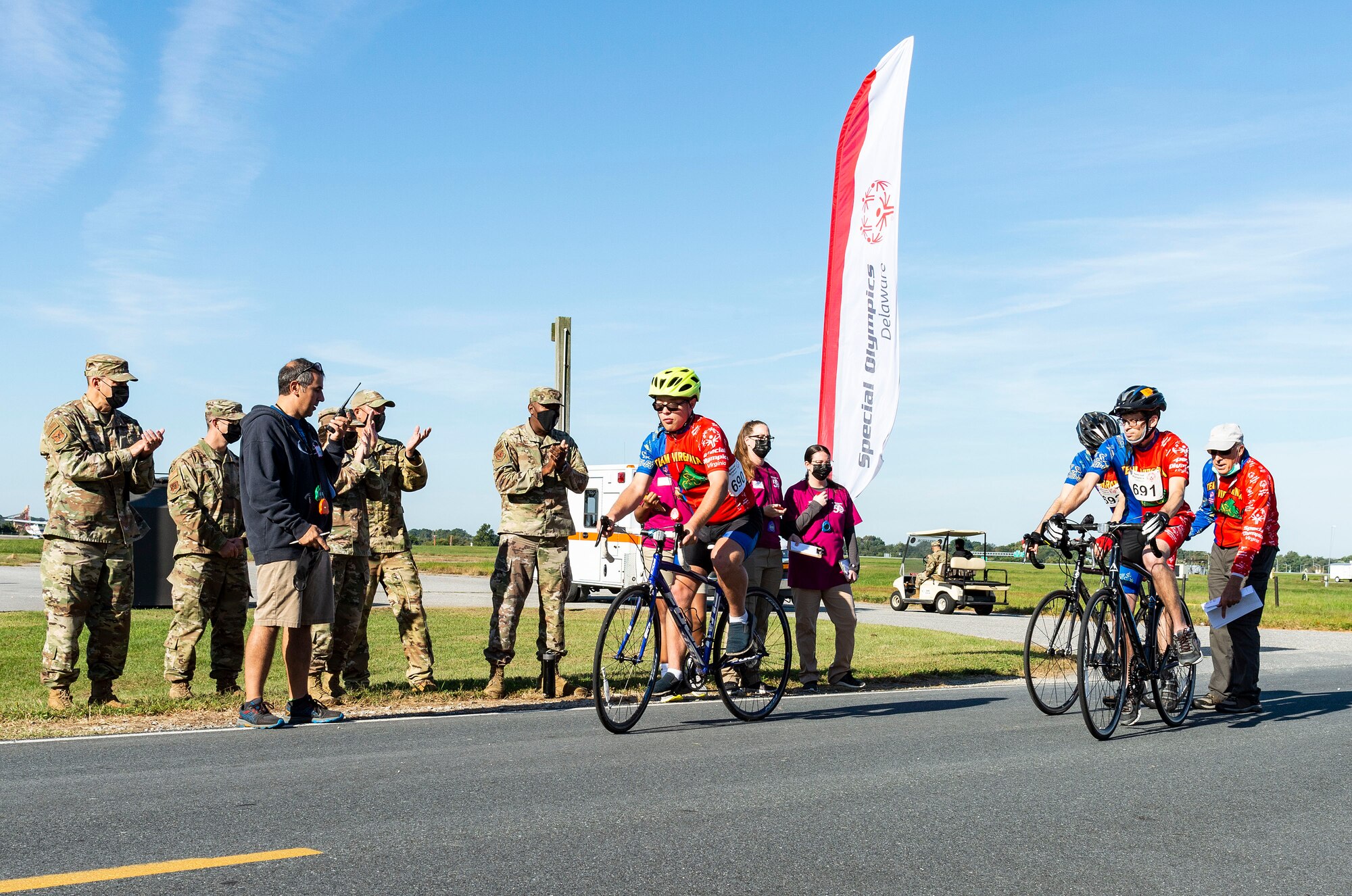 Team Dover senior leadership cheer on cyclists at the start of the 10K race at the 2021 Special Olympics Delaware Cycling Classic at Dover Air Force Base, Delaware, Oct. 2, 2021. Team Dover senior leadership presented medals to the top three finishers in each event. More than 90 volunteers helped with setting up race courses and recording individual times of competitors. (U.S. Air Force photo by Roland Balik)