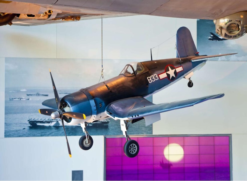 An aircraft hangs on display in a museum.