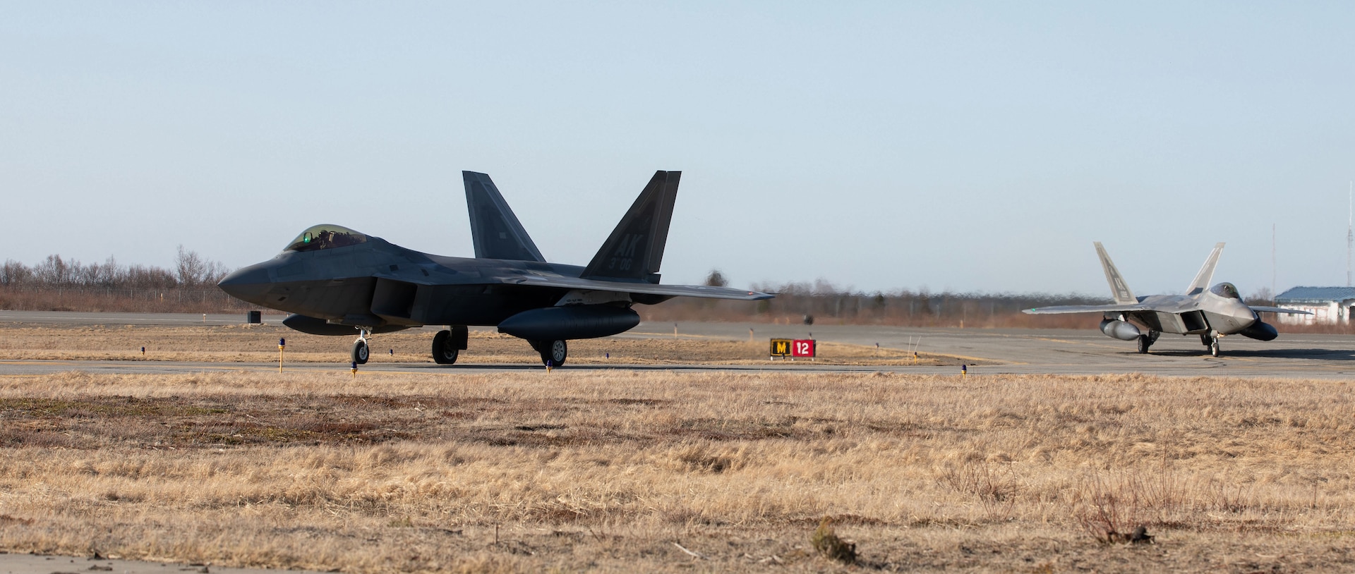 Two F-22 Raptor fighter jets assigned to the 90th Fighter Squadron, 3rd Wing, Joint Base Elmendorf-Richardson, Alaska, taxi in King Salmon, Alaska May 5, 2021 in support of flight operations above the Joint Pacific Alaska Range Complex and Gulf of Alaska during Exercise Northern Edge 2021 (NE21).