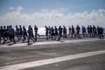 Sailors run on the flight deck of an aircraft carrier.