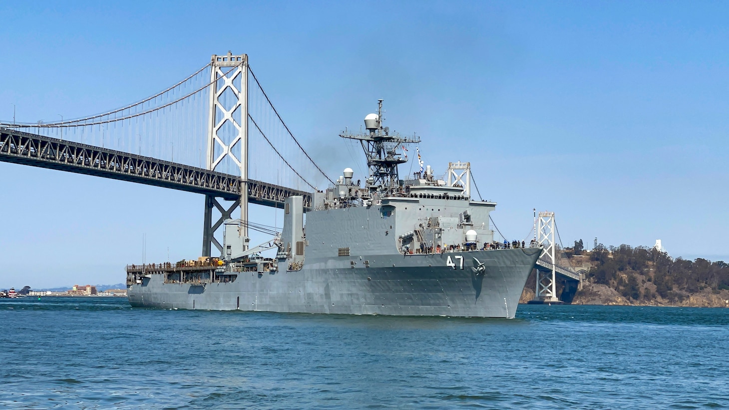 SAN FRANCISCO (Oct. 4, 2021) Whidbey Island-class amphibious dock landing ship USS Rushmore (LSD 47) crosses under the San Francisco-Oakland Bay Bridge arriving in San Francisco in support of San Francisco Fleet Week (SFFW) 2021. SFFW is an opportunity for the American public to meet their Navy, Marine Corps and Coast Guard teams and experience America's sea services. During fleet week, service members participate in various community service events, showcase capabilities and equipment to the community, and enjoy the hospitality of the city and its surrounding areas. (U.S. Navy photo by Mass Communication Specialist 2nd Class Jasen Moreno-Garcia/Released)