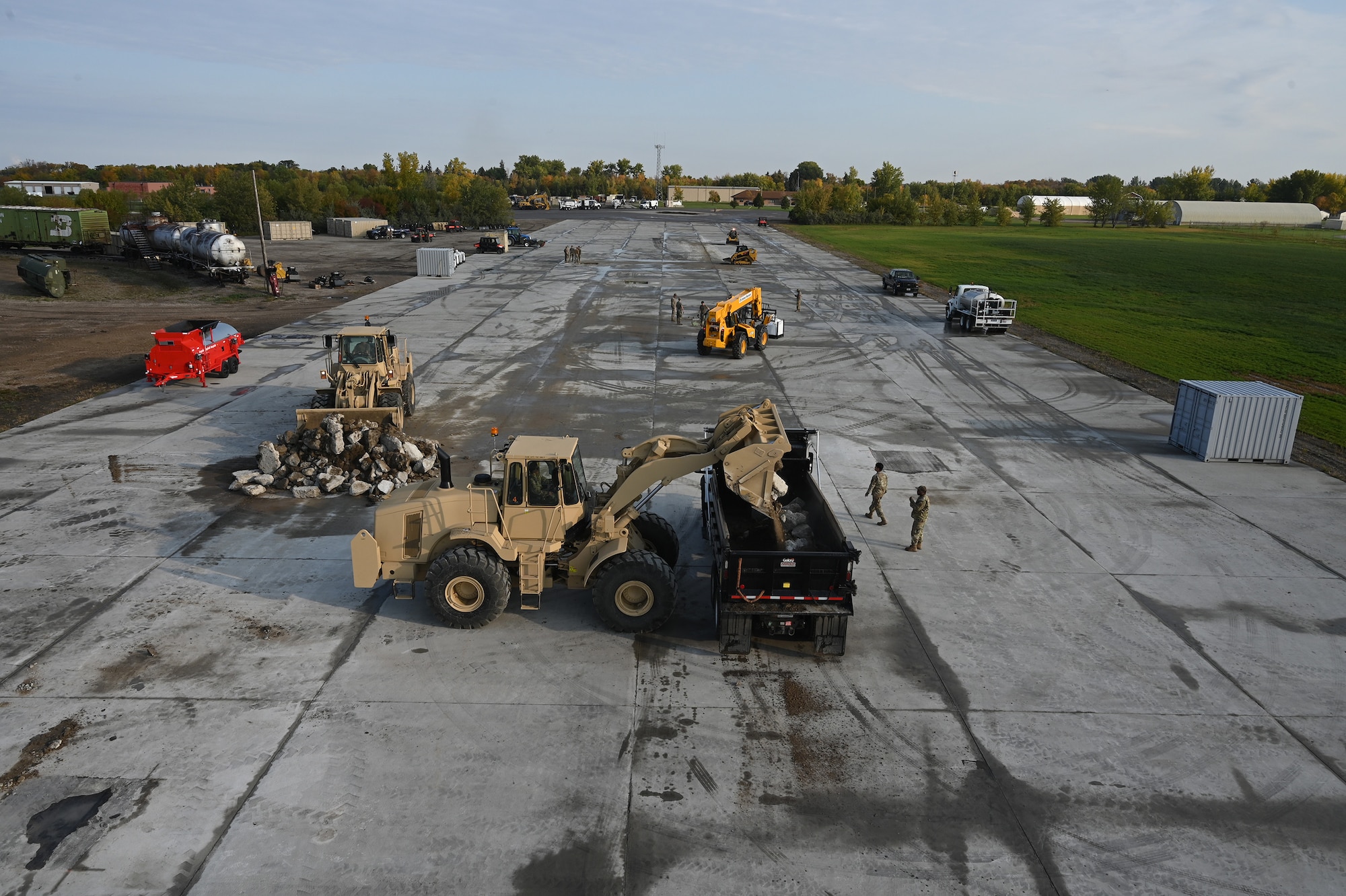 Heavy equipment and military personnel can be seen patch square holes on a concrete training runway from an elevated view at the North Dakota Air National Guard Regional Training Site, Fargo, N.D., Sept. 30, 2021.