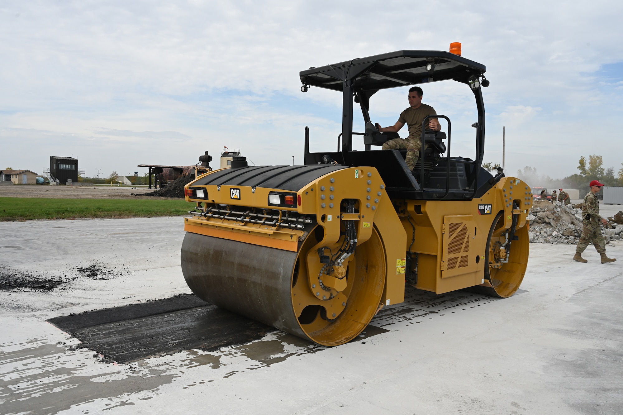 A military member operates an asphalt compactor as he levels an asphalt patch on a concrete training runway at the North Dakota Air National Guard Regional Training Site, Fargo, N.D., Sept, 29, 2021.