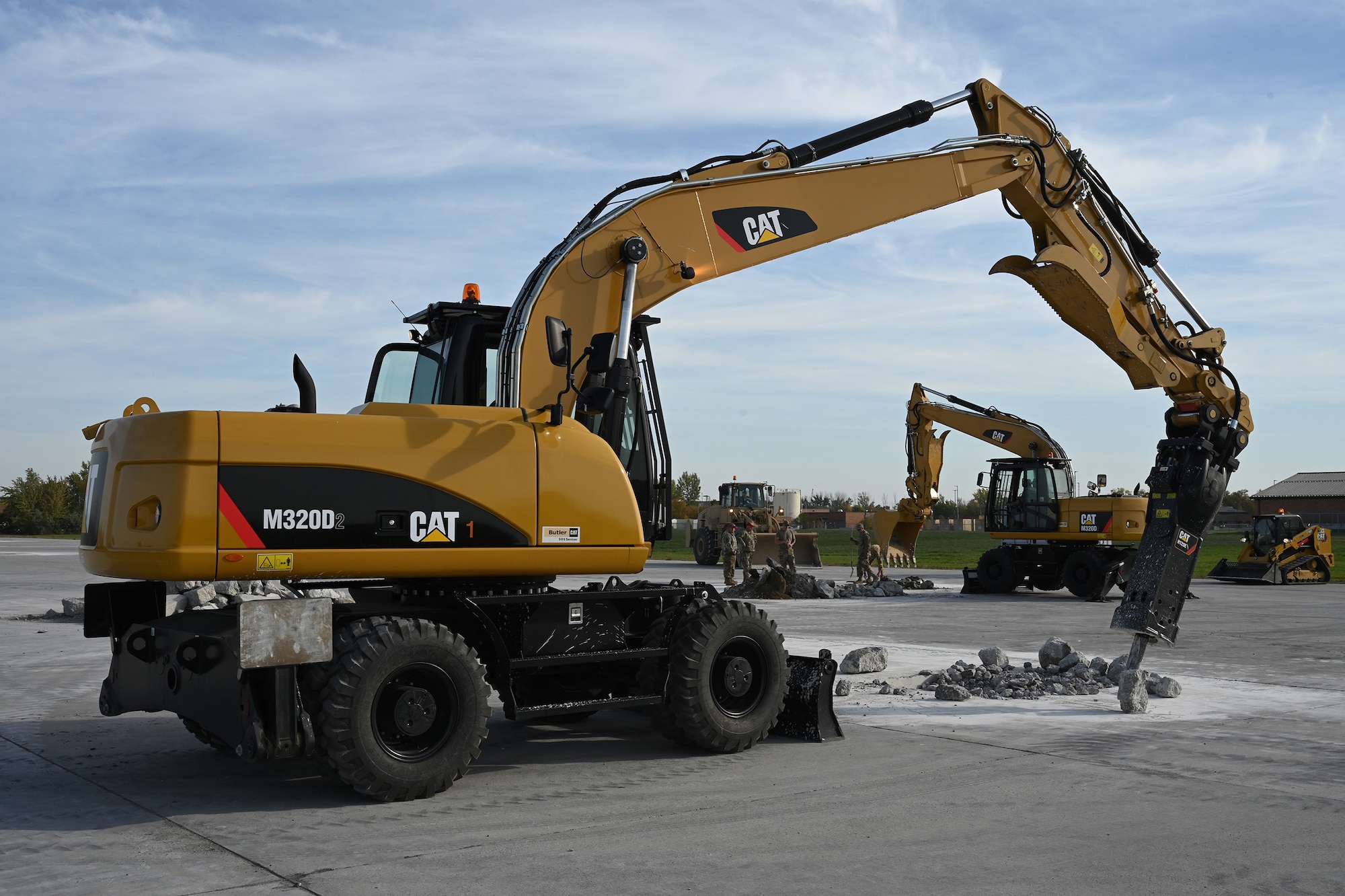 Two large excavators are operated by military members as they patch holes on a concrete training runway at the North Dakota Air National Guard Regional Training Site, Fargo, N.D., Sept. 29, 2021