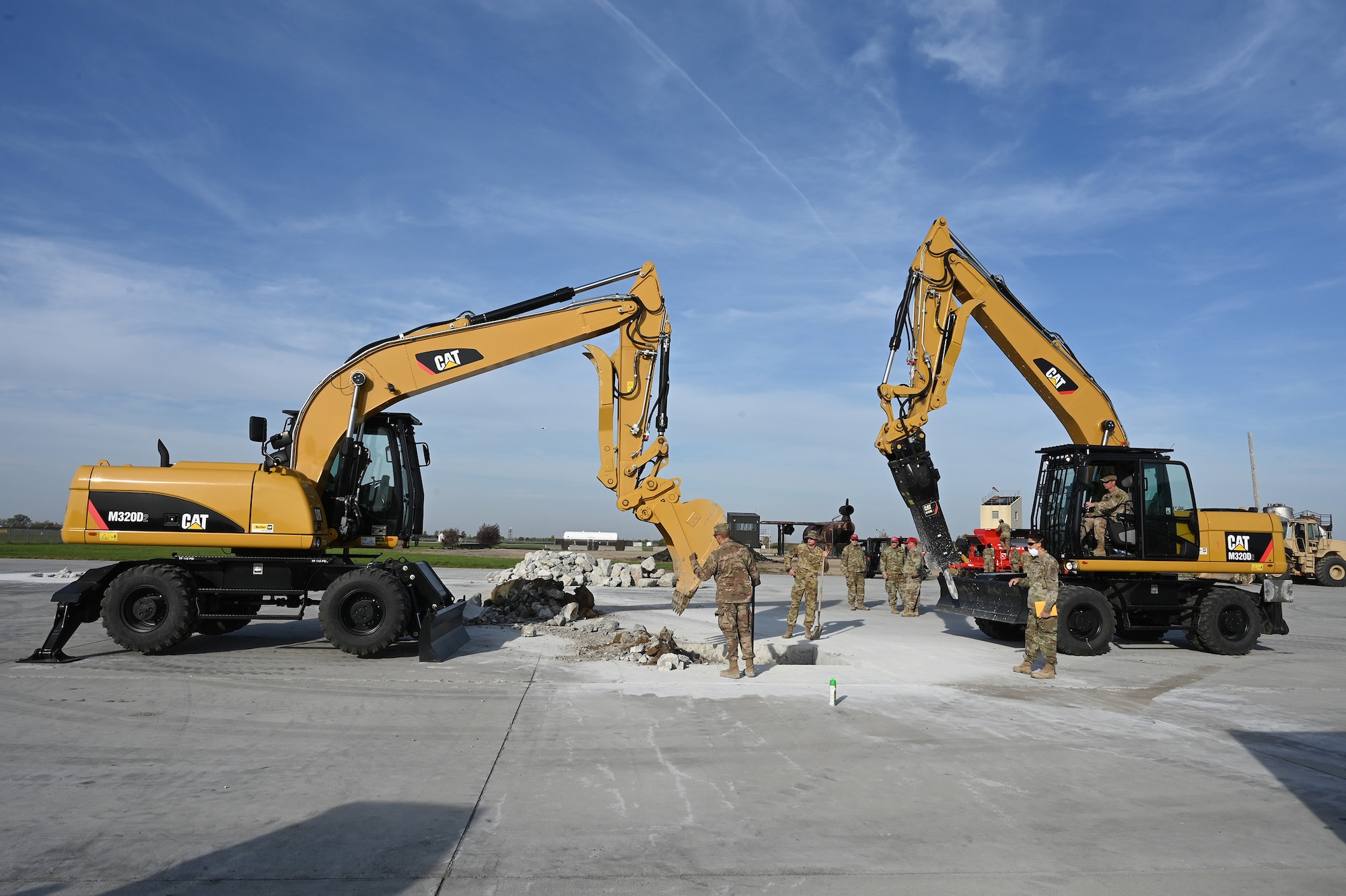 Two large excavators are used by military members to repair holes in a concrete training runway at the North Dakota Air National Guard Regional Training Site, Fargo, N.D., Sept. 29, 2021.