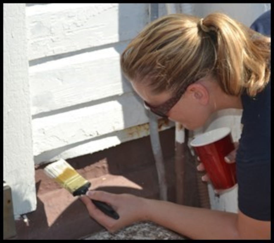 A 2012 photograph of Coast Guard Chief Petty Officer Kristin Antonides of Port Security Unit 309 painting the quarters building in her spare time. (Used with permission)