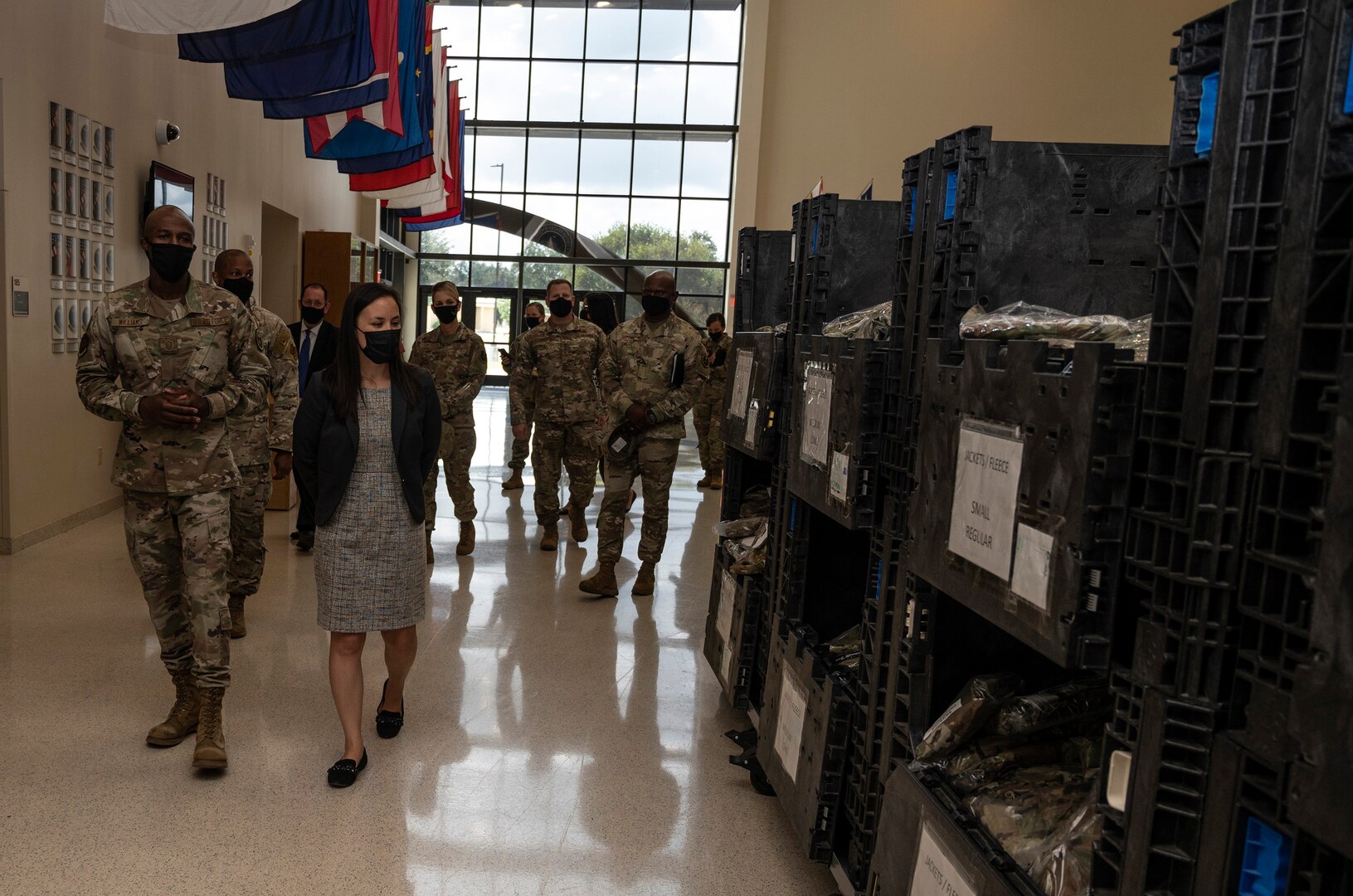Undersecretary of the Air Force walking past BMT gear issued to trainees.