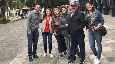 a group of six family members stand together in a plaza