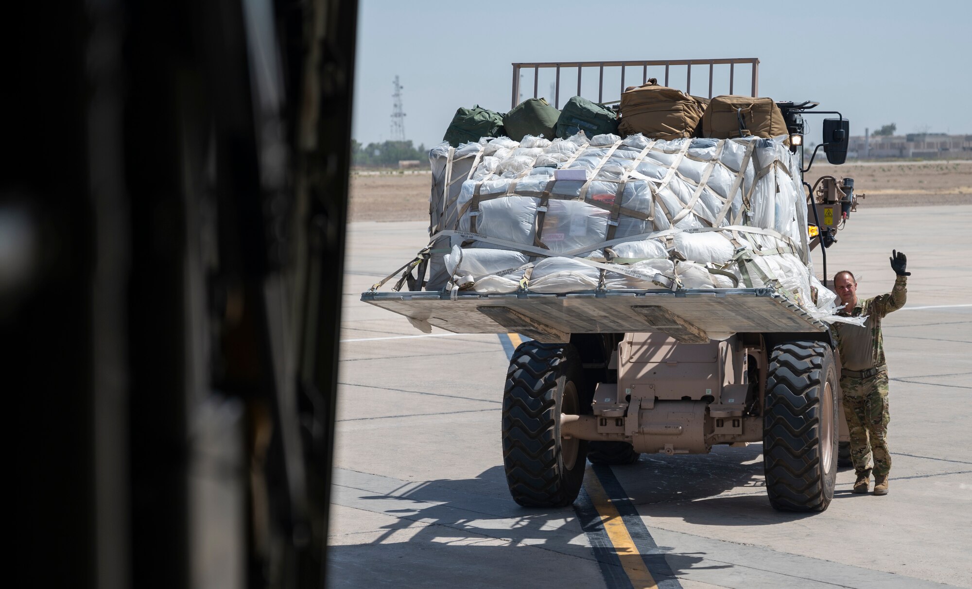 Senior Master Sgt. Mickey Dixon, a loadmaster with the 779th Expeditionary Airlift Squadron, guides cargo towards a C-130H Hercules in Iraq Sept. 16, 2021.