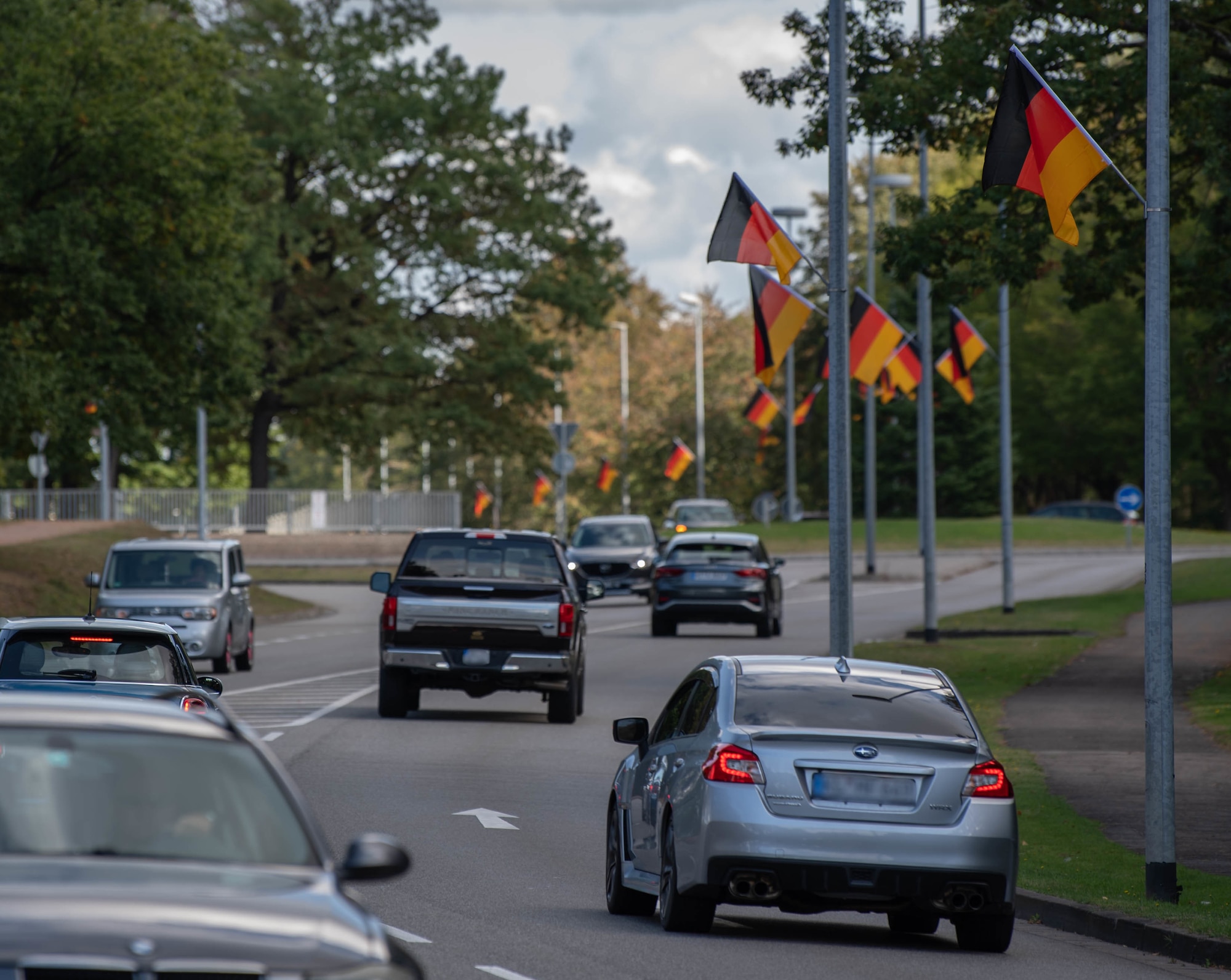 Vehicles drive by German flags along Kisling Memorial Drive at Ramstein Air Base, Germany, Sept. 30, 2021.