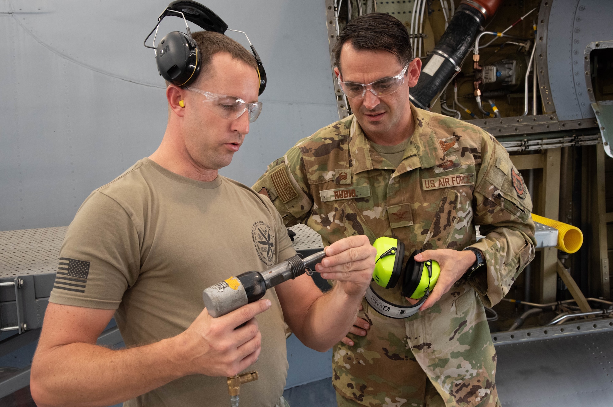 An Airman shows Col. Rubio how to work a power tool.