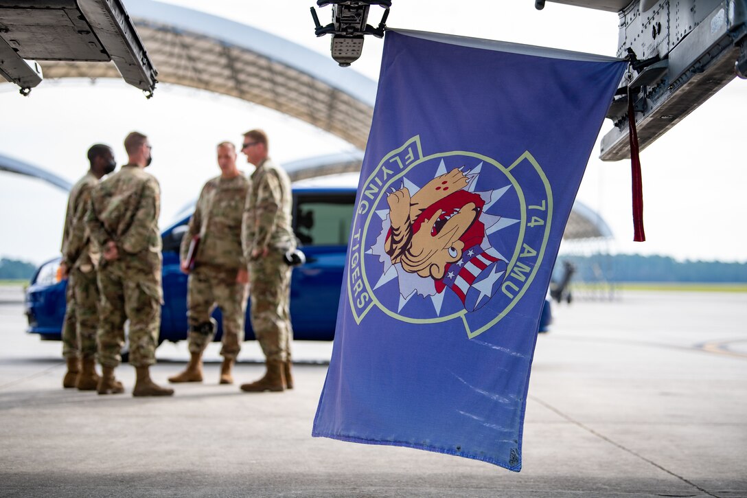 A photo of Airmen behind flag.
