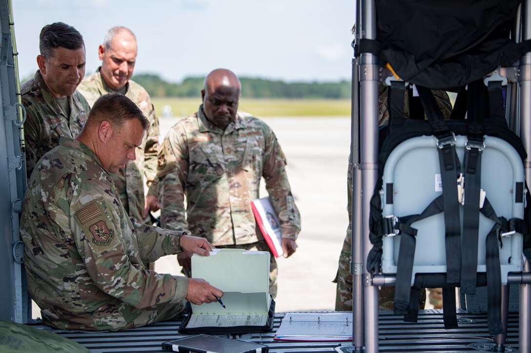 A photo of Airmen reading from binder.