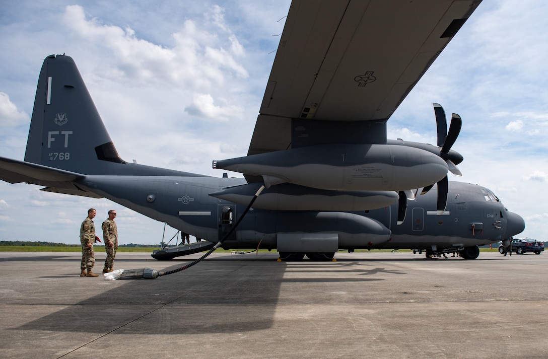 A photo of Airmen standing by an aircraft.