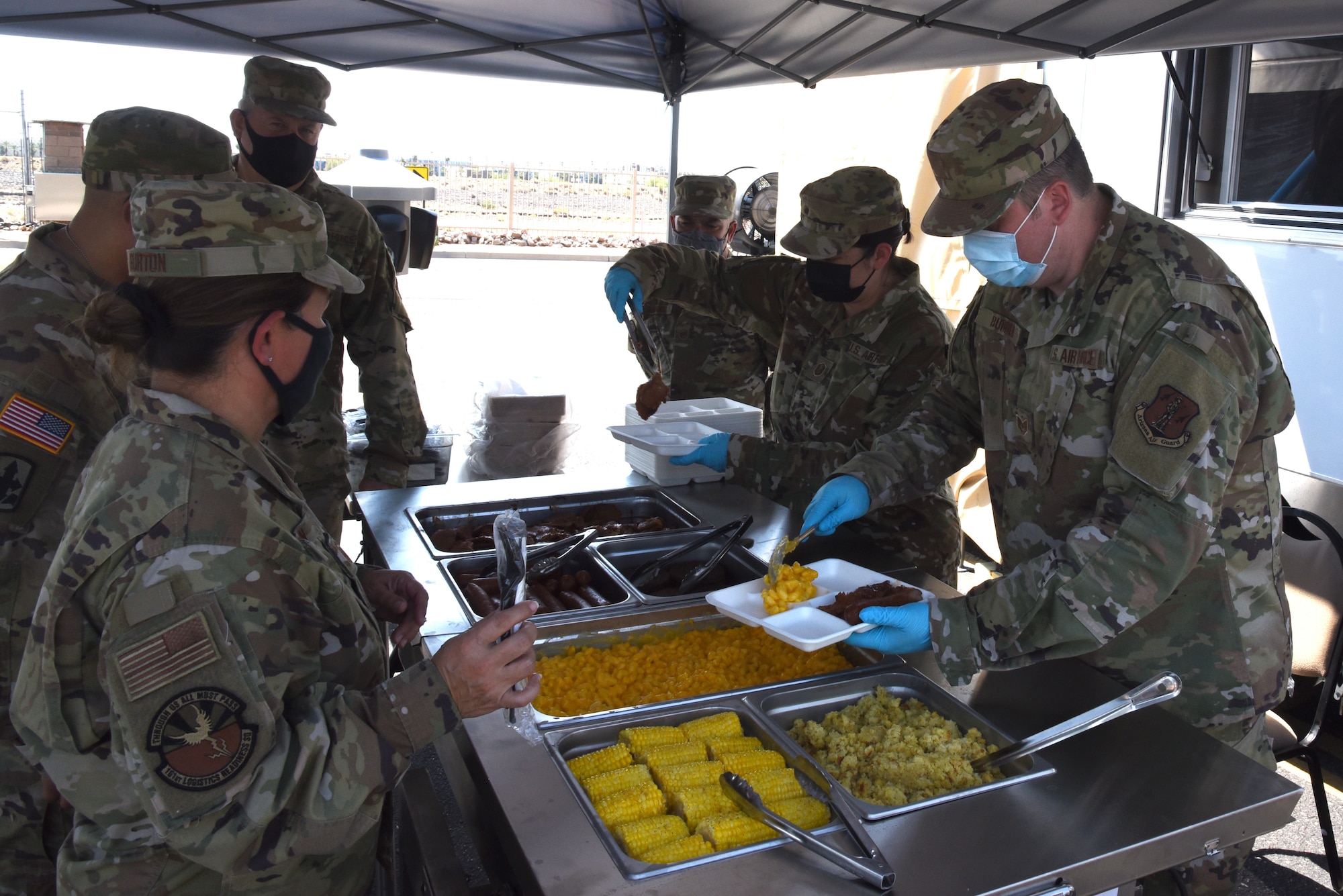 Airmen from 161st Services Squadron, Arizona Air National Guard, serve their first meal cooked in the DRMKT to Arizona Guard leadership, Aug 3, 2021, Goldwater Air National Guard Base, Arizona.  The distinguished guests were first given a brief on the DRMKT capabilities, followed by a quick tour of the trailer in its operational configuration.(U.S. Air Force photo by Tech. Sgt. Anthony Reynolds)