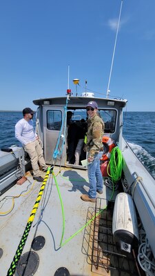 Ryan Beatley and Blair Atcheson finish securing the magnetometer cable for the remote sensing survey on the NUWC dive boat.