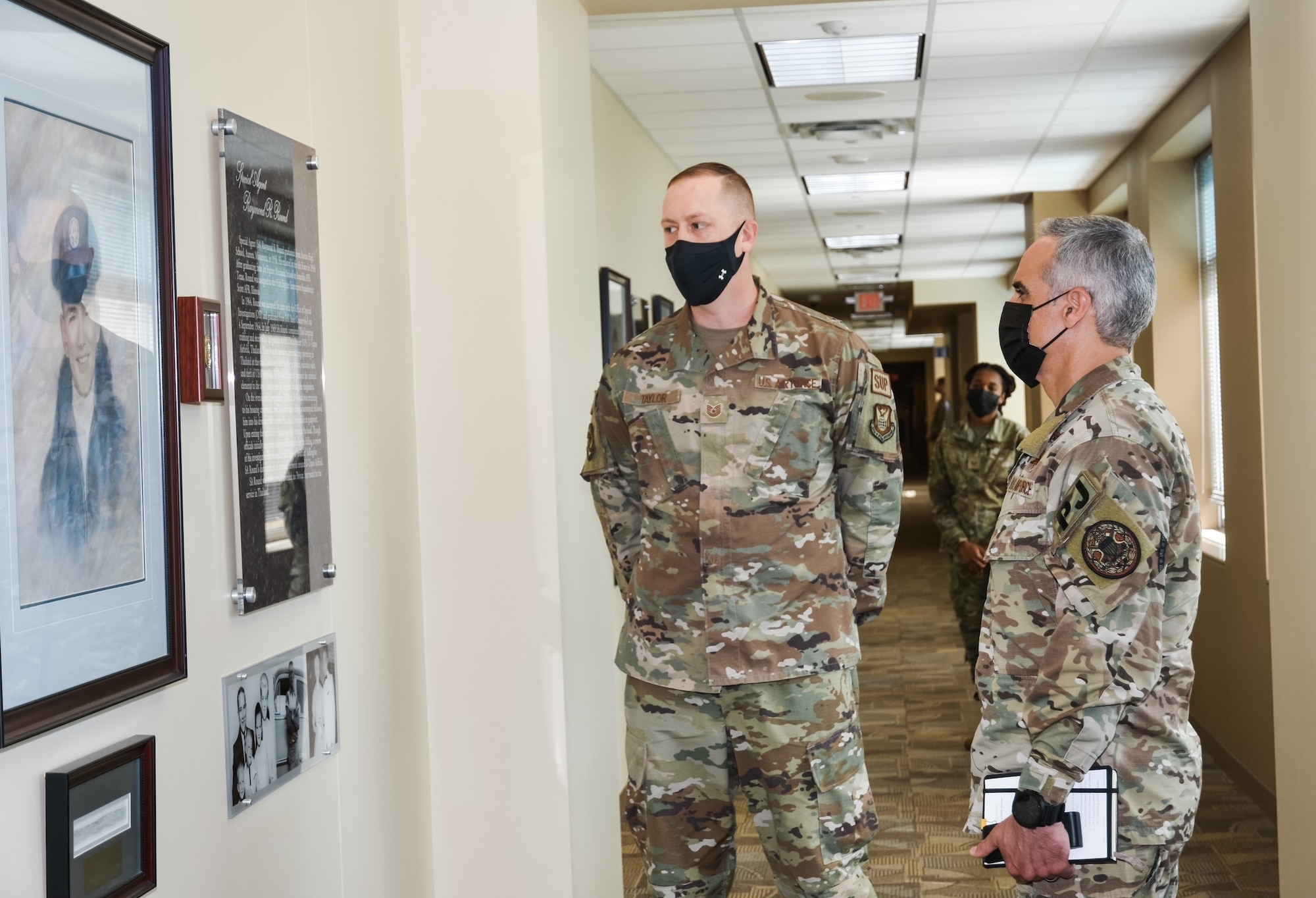 Tech. Sgt. William Taylor briefs the legacy of Office of Special Investigations Fallen Special Agent Raymond Round in the OSI Hall of Heroes, to SEAC Ramon Colon-Lopez, the Senior Enlisted Advisor to the Chairman of the Joint Chiefs of Staff, during his visit to OSI headquarters at Quantico, Va., Oct. 1, 2021. The SEAC visit supported OSI’s observance of National Hispanic Heritage Month and this year’s theme, Esperanza: A Celebration of Hispanic Heritage and Hope. (Photo by SA Christina Williams)