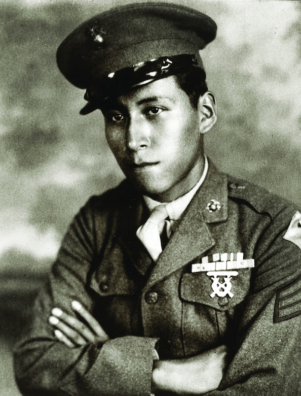 A soldier wearing a cap poses for a photo.
