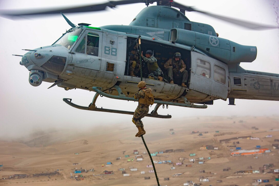 A Marine fast-ropes from an airborne helicopter.