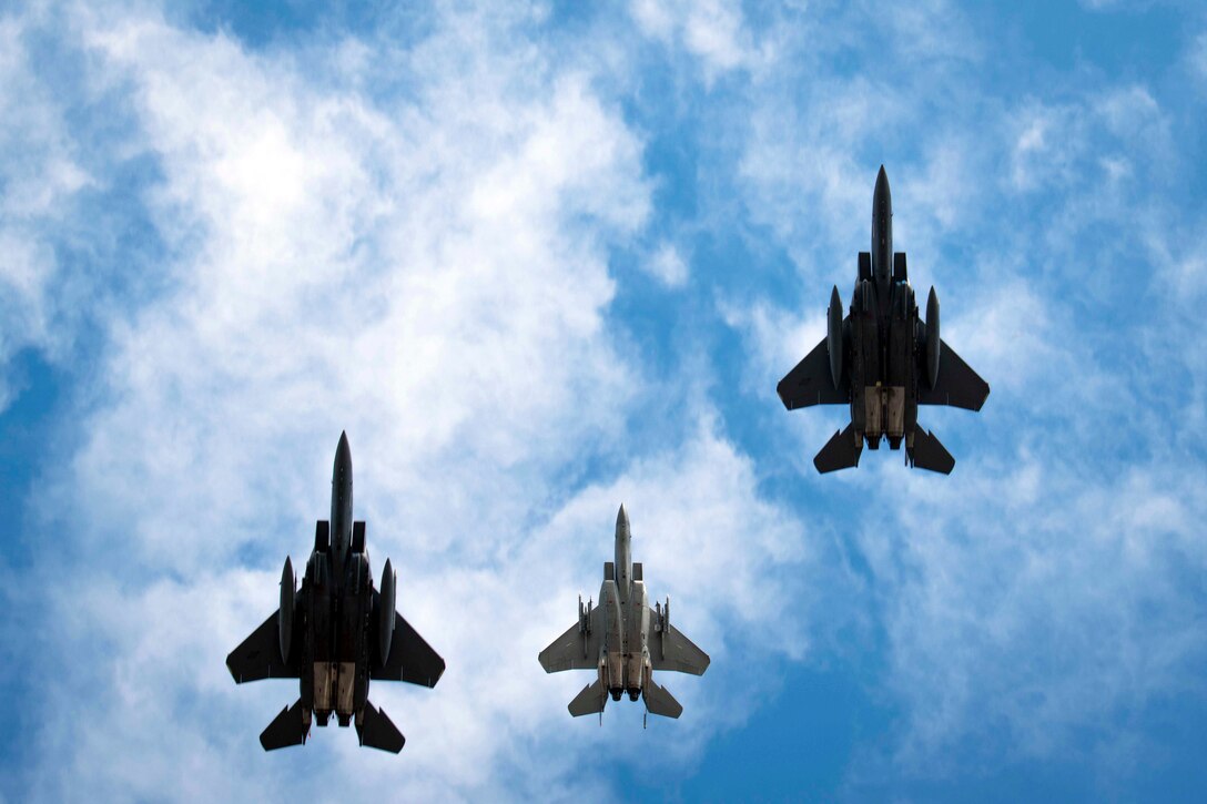 Three Air Force aircraft fly in formation.