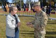 Marina Hilbert, left, receives a commander's coin from Sgt. Maj. Francis Famularcano, sergeant major for U.S. Army Medical Materiel Center-Europe. Hilbert maintains a website that provides information and nostalgic photos about the Husterhoeh Kaserne. USAMMCE recently moved from the kaserne after having been at the installation since 1975.