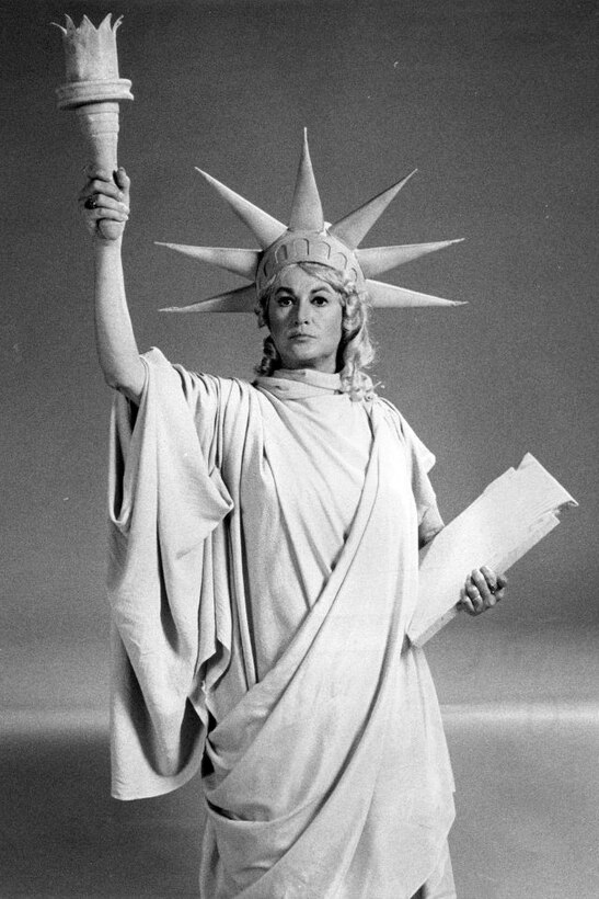 A woman poses as the Statue of Liberty.