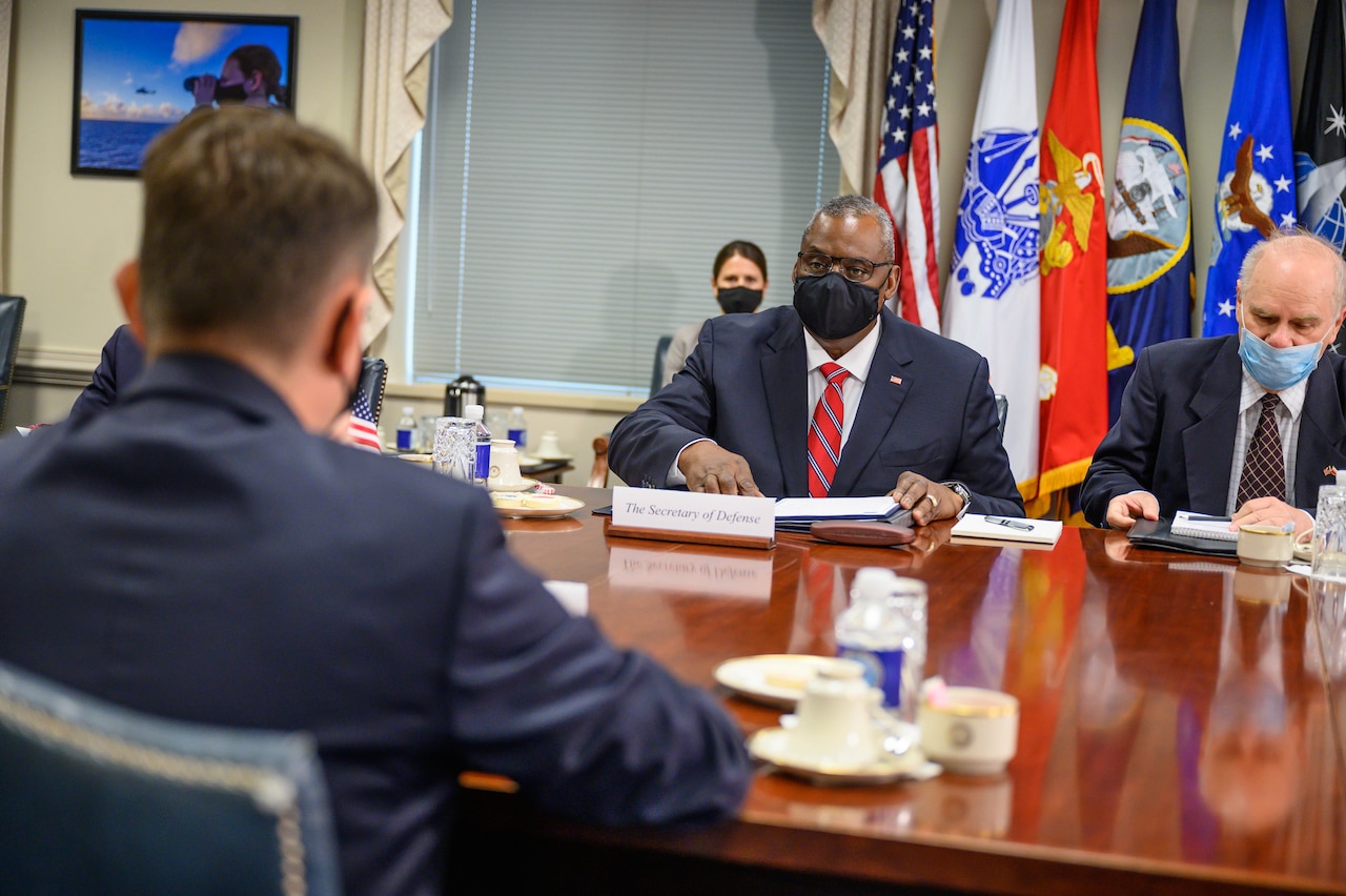 People hold a meeting around a conference table.