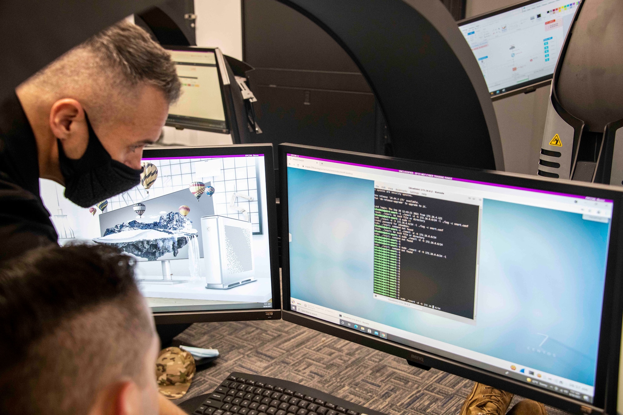 Christopher McMall, 97th Communications Squadron (CS) Mission Defense Team (MDT) special missions flight director, assists U.S. Space Force 1st Lt. Christopher Clement, 97th CS MDT officer in charge, as he runs code during their first cyber defense exercise at Altus Air Force Base, Oklahoma, Sept. 30, 2021. This exercise was in partnership with the U.S. Air National Guard’s 229th Cyberspace Operation Squadron from Vermont. (U.S. Air Force photo by Staff Sgt. Cody Dowell)