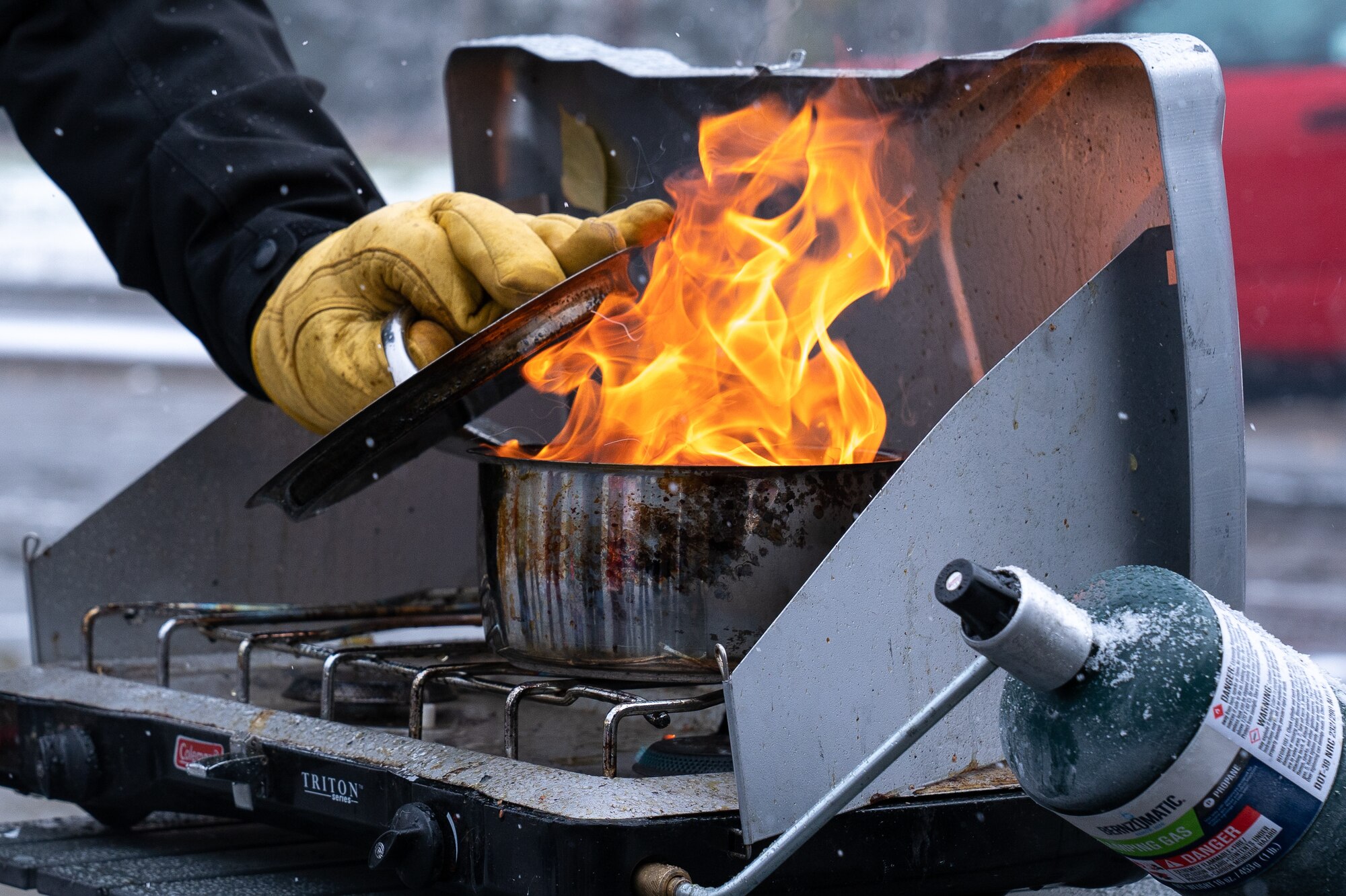 Jon Burpee, a 673d Civil Engineer Squadron fire inspector, steps back from a grease fire during Fire Prevention Day.