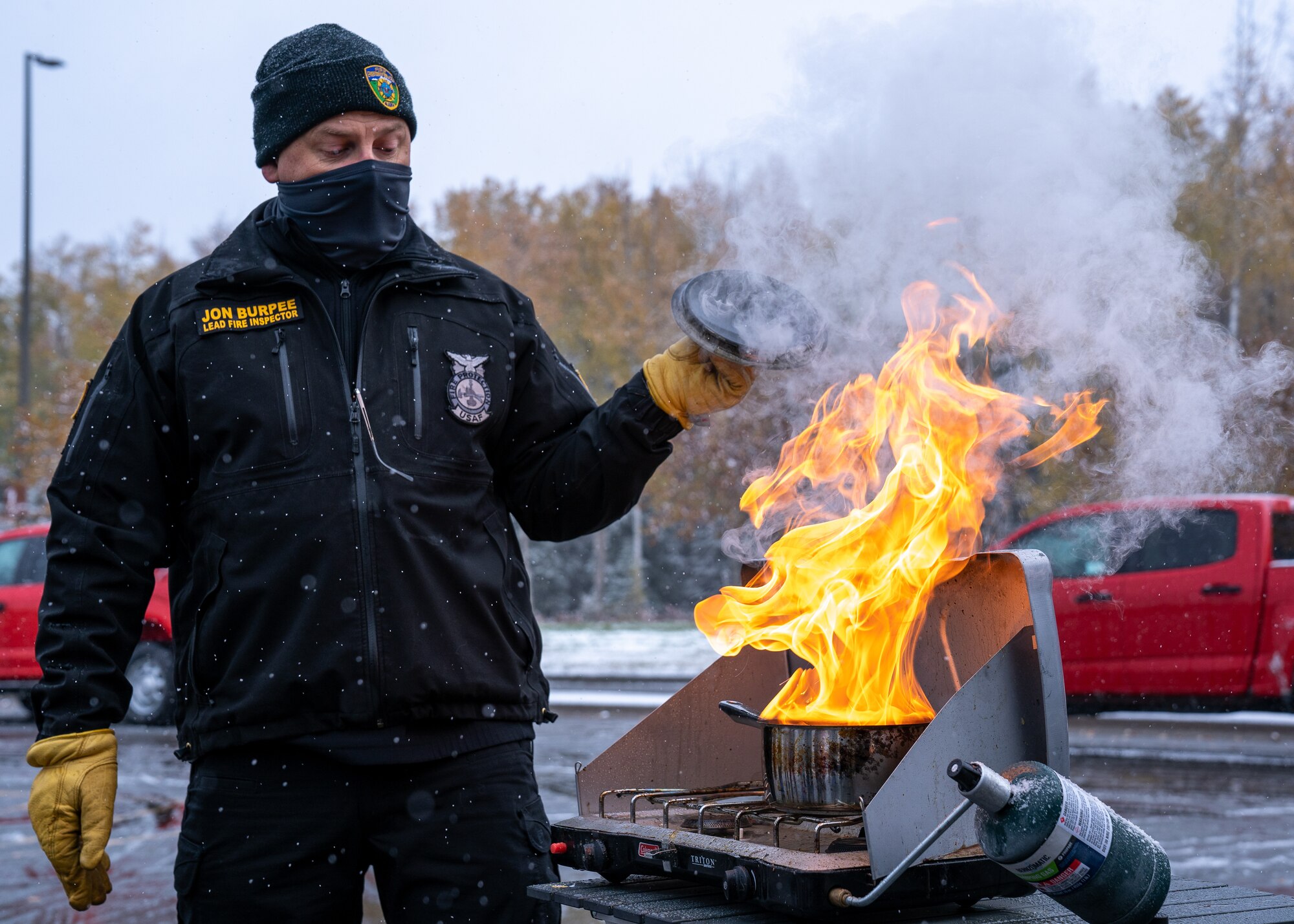 Jon Burpee, a 673d Civil Engineer Squadron fire inspector, steps back from a grease fire during Fire Prevention Day.