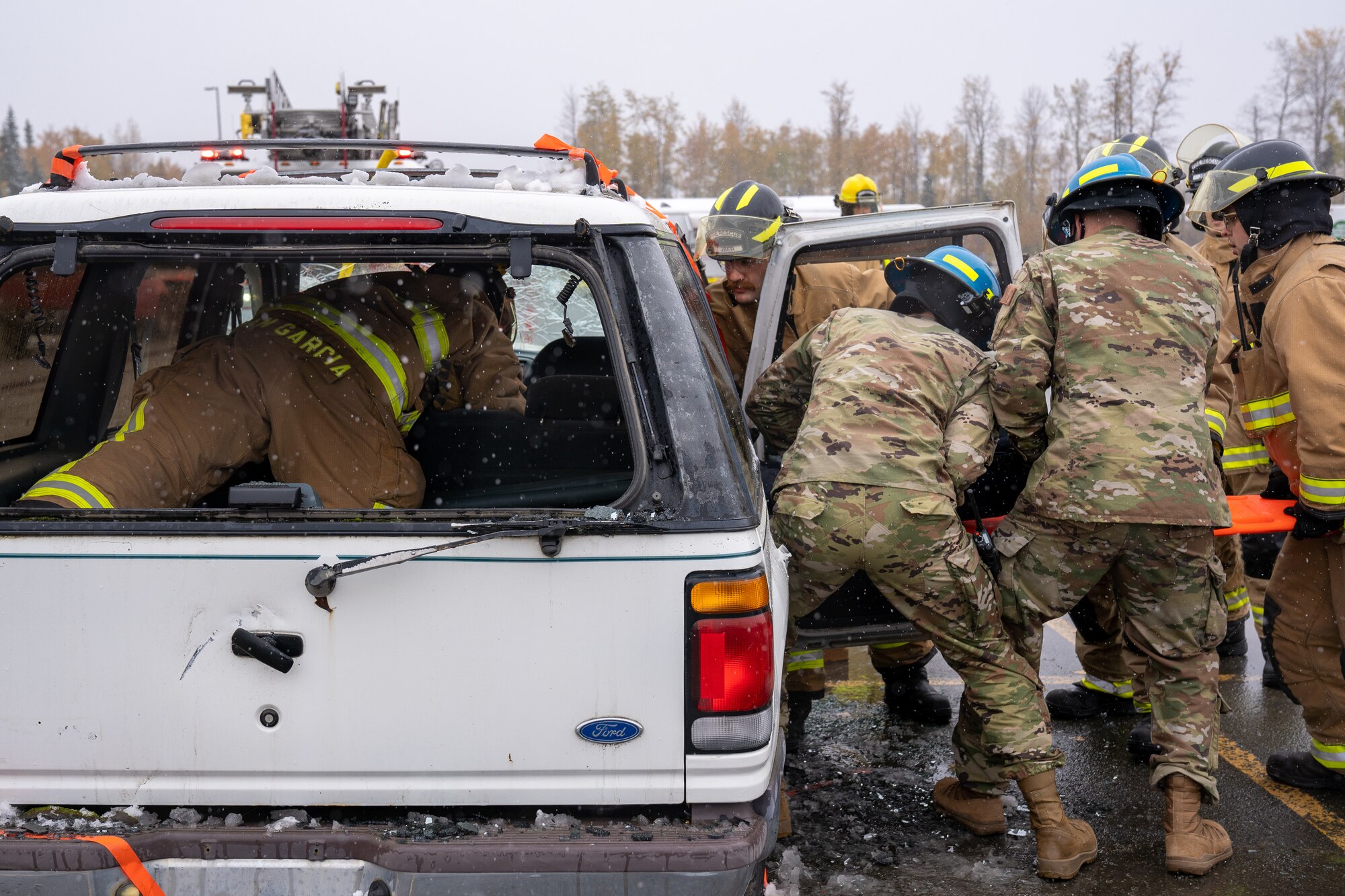 Firefighters assigned to the 673d Civil Engineer Squadron pull a mannequin out of a damaged car during a vehicle-extrication demonstration for Fire Prevention Day.