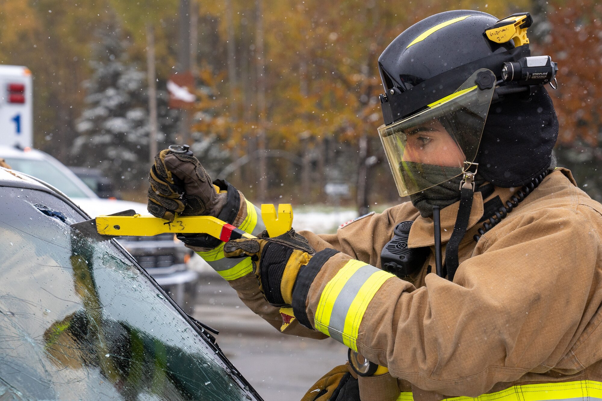 Airman 1st Class Jose Guzman Garcia, a 673d Civil Engineer Squadron firefighter, uses a glass cutter to remove the windshield of a damaged car for a vehicle-extrication demonstration during Fire Prevention Day.