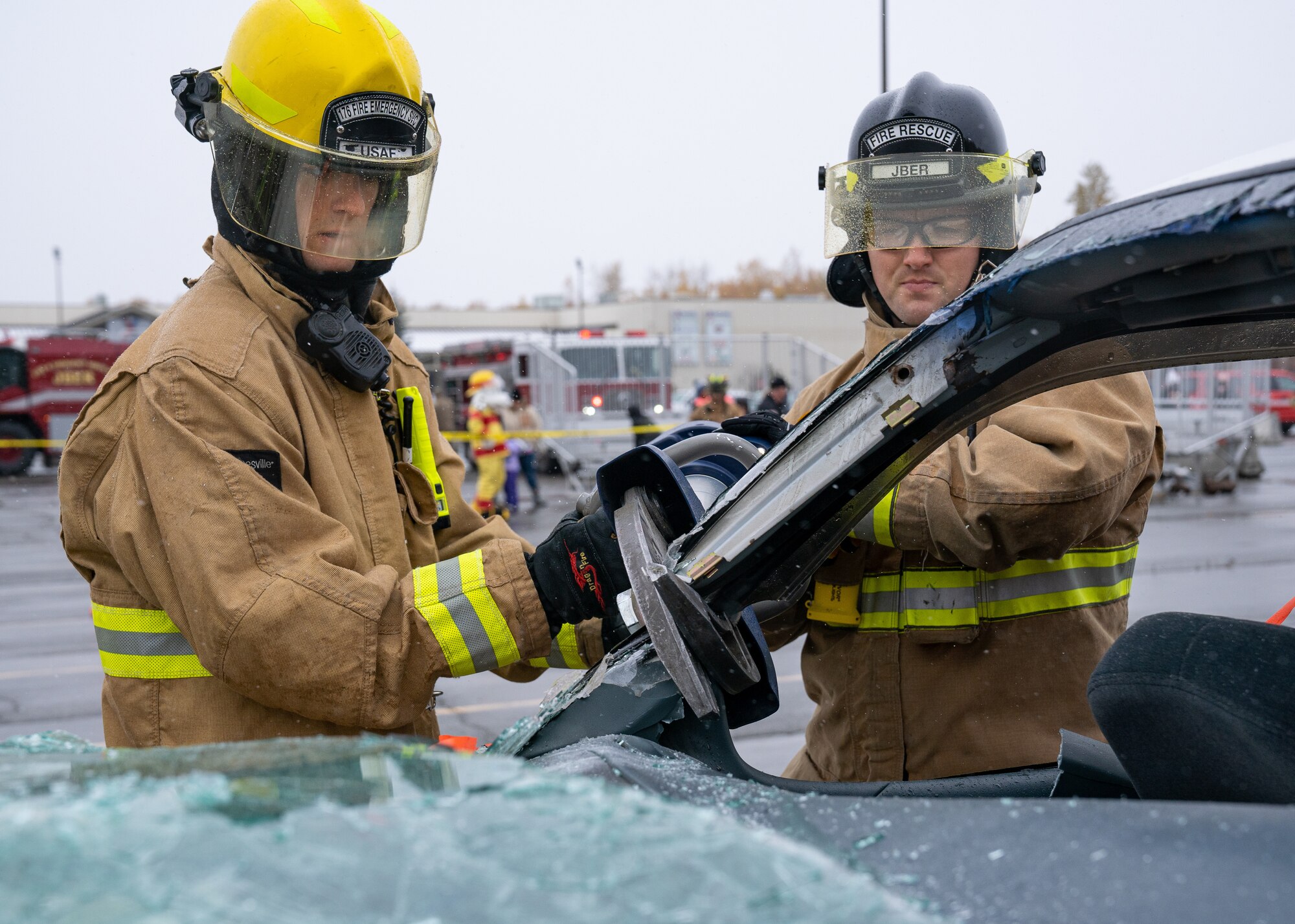 Wayland Nease and U.S. Air Force Airman Joshua Fleming, both 673d Civil Engineer Squadron firefighters, use the Jaws of Life to cut through a damaged car for a vehicle-extrication demonstration during Fire Prevention Day.