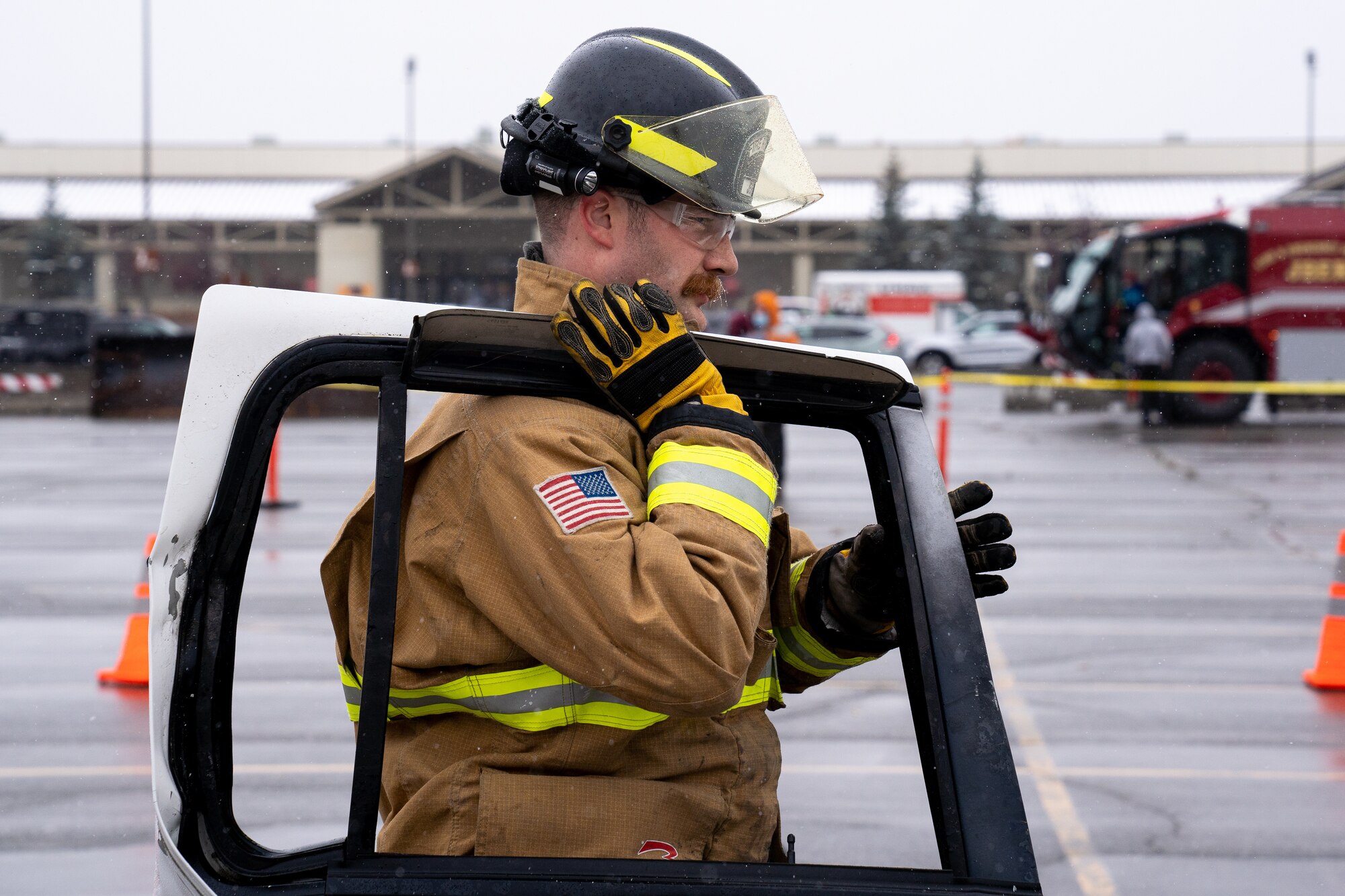 Nicholas Parks, a 673d Civil Engineer Squadron firefighter, carries a removed car door after a vehicle-extrication demonstration during Fire Prevention Day.