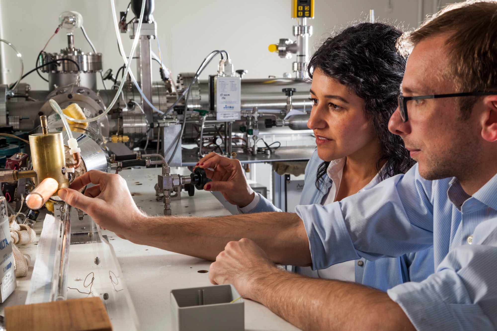 Air Force Research Laboratory scientists, Dr. Nicholas Shuman and Jenny Sanchez, conduct an experiment in the Space Vehicles Directorate’s plasma chemistry lab used to understand how the space environment affects spacecraft in orbit. (Courtesy photo)