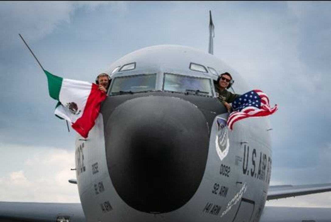Aircrew from the 92nd Air Refueling Wing, Fairchild Air Force Base, WA, wave the U.S. and Mexican flags during the Feria Aeroespacial México (FAMEX), or the Mexico Aerospace Fair at Base Aérea No.1 de Santa Lucía, Mexico, Sep. 25, 2021. The U.S. participated in the air show as the “country of honor,” a special designation signifying the partnership and cooperation between both countries. (U.S. Air Force photo by 2nd Lt. Danny Rangel)