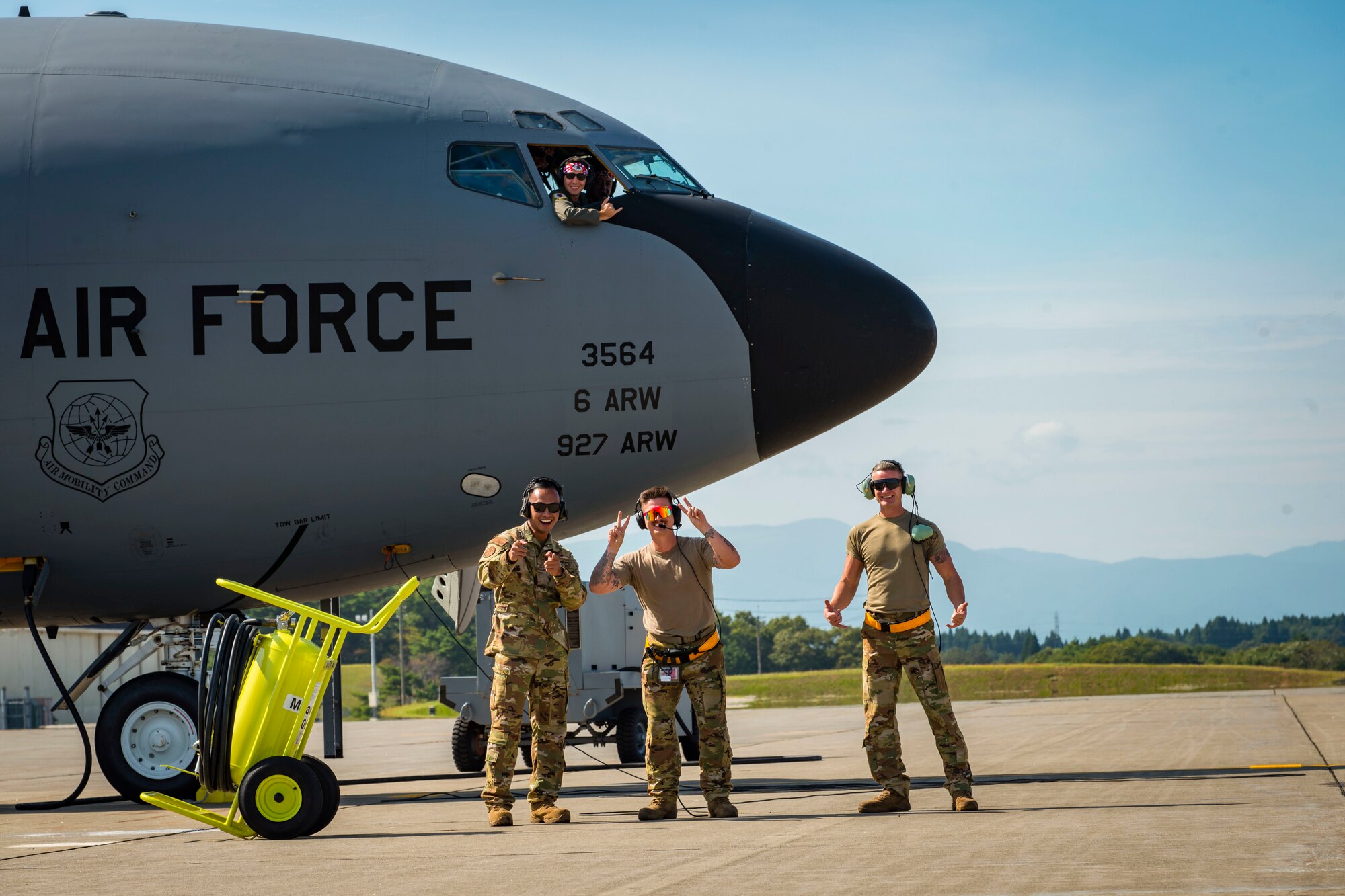 Airmen pose in front of aircraft.