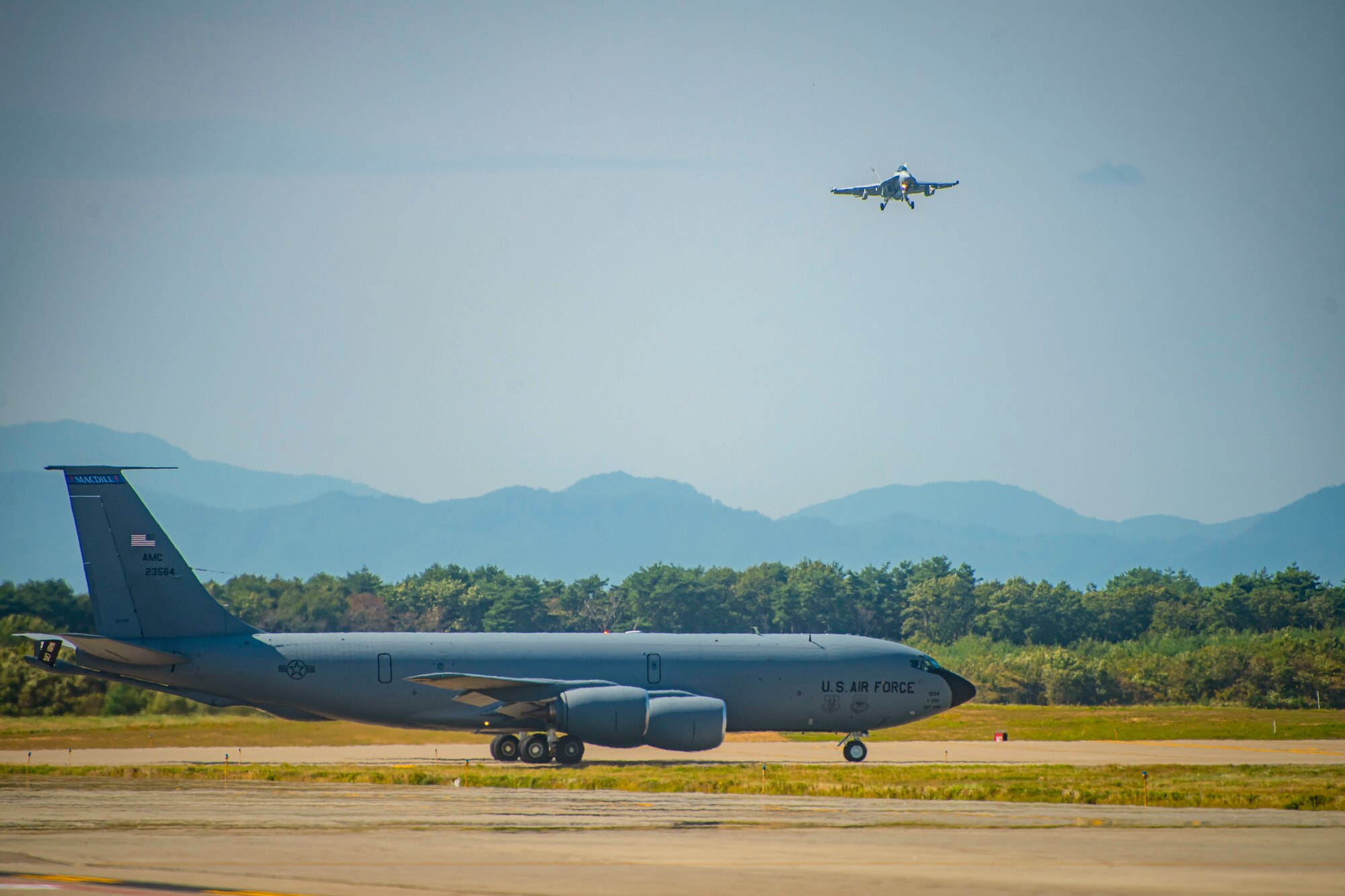 Fighter jet lands while a plane prepares to take off from Misawa Air Base runway .