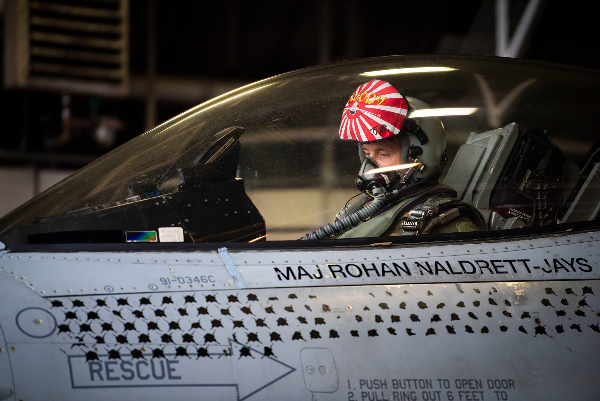 Pilot sits in cockpit of fighter jet preparing to take off.