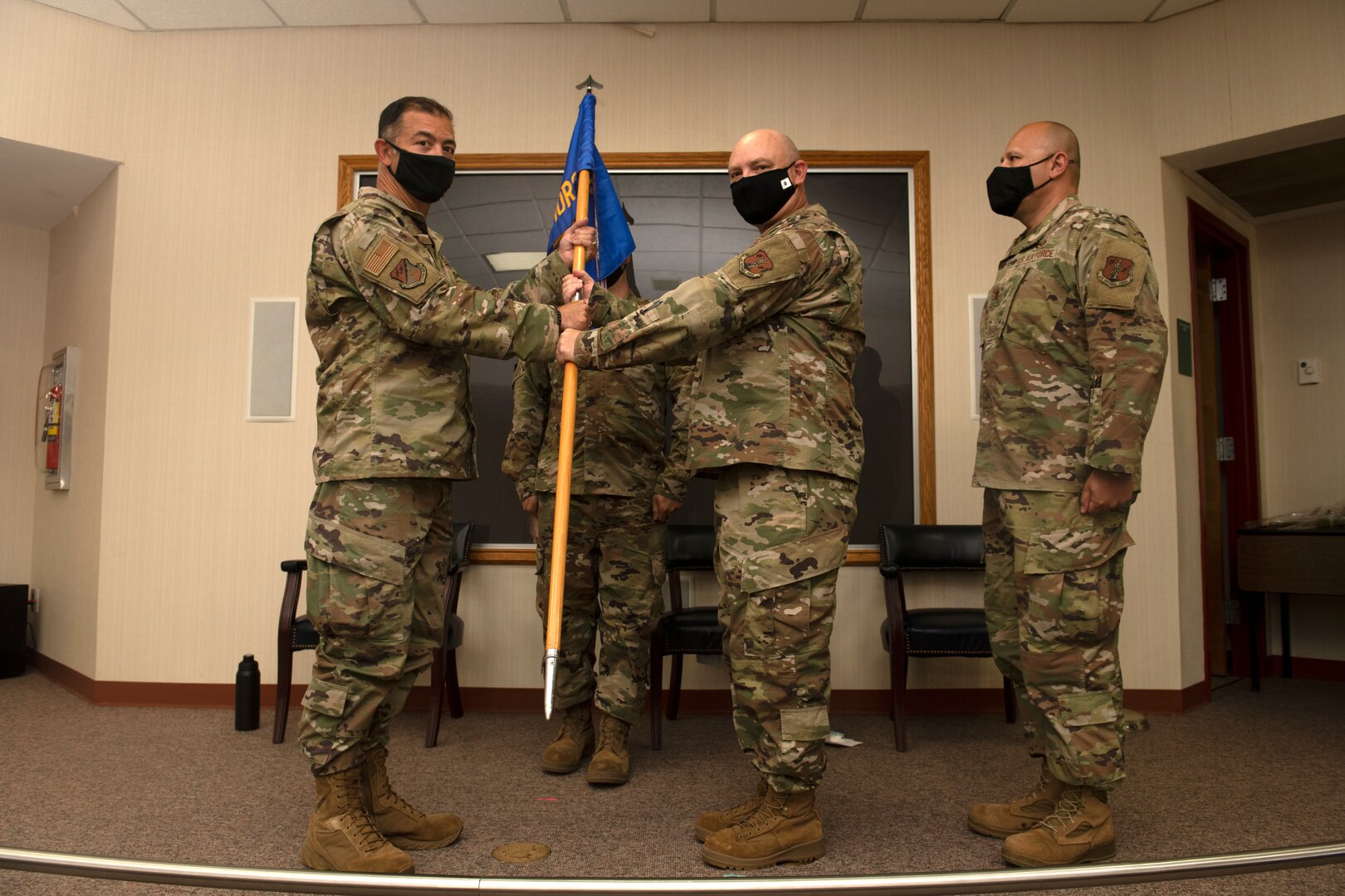 Lt. Col. Jeffrey E. Getz passes the 203rd Rapid Engineer Deployable Heavy Operational Repair Squadron Engineers (RED HORSE) guidon to Col. David Lands, 192nd Mission Support Group commander, left, marking the end of his command during a change of command ceremony Oct. 2, 2021, at State Military Reservation in Virginia Beach, Virginia.