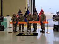 Pennsylvania Adjutant General Maj. Gen. Mark Schindler, center, cuts the ribbon during a ribbon-cutting ceremony for the UH-60V Black Hawk helicopter on Oct. 6, 2021, at the Eastern Army National Guard Aviation Training Site at Fort Indiantown Gap, Pa. EAATS was the first unit in the Army – active duty, National Guard or Army Reserve – to receive the new variant.
