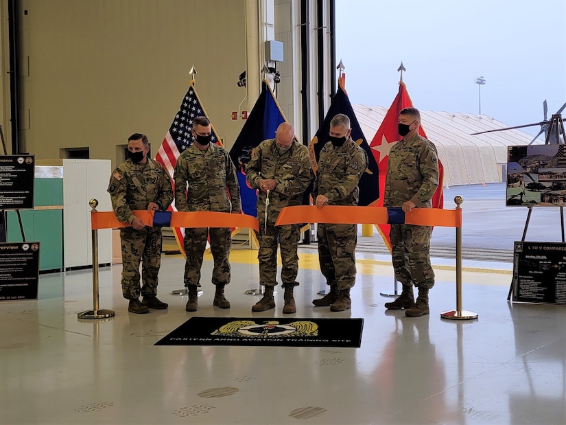 Pennsylvania Adjutant General Maj. Gen. Mark Schindler, center, cuts the ribbon during a ribbon-cutting ceremony for the UH-60V Black Hawk helicopter on Oct. 6, 2021, at the Eastern Army National Guard Aviation Training Site at Fort Indiantown Gap, Pa. EAATS was the first unit in the Army – active duty, National Guard or Army Reserve – to receive the new variant.