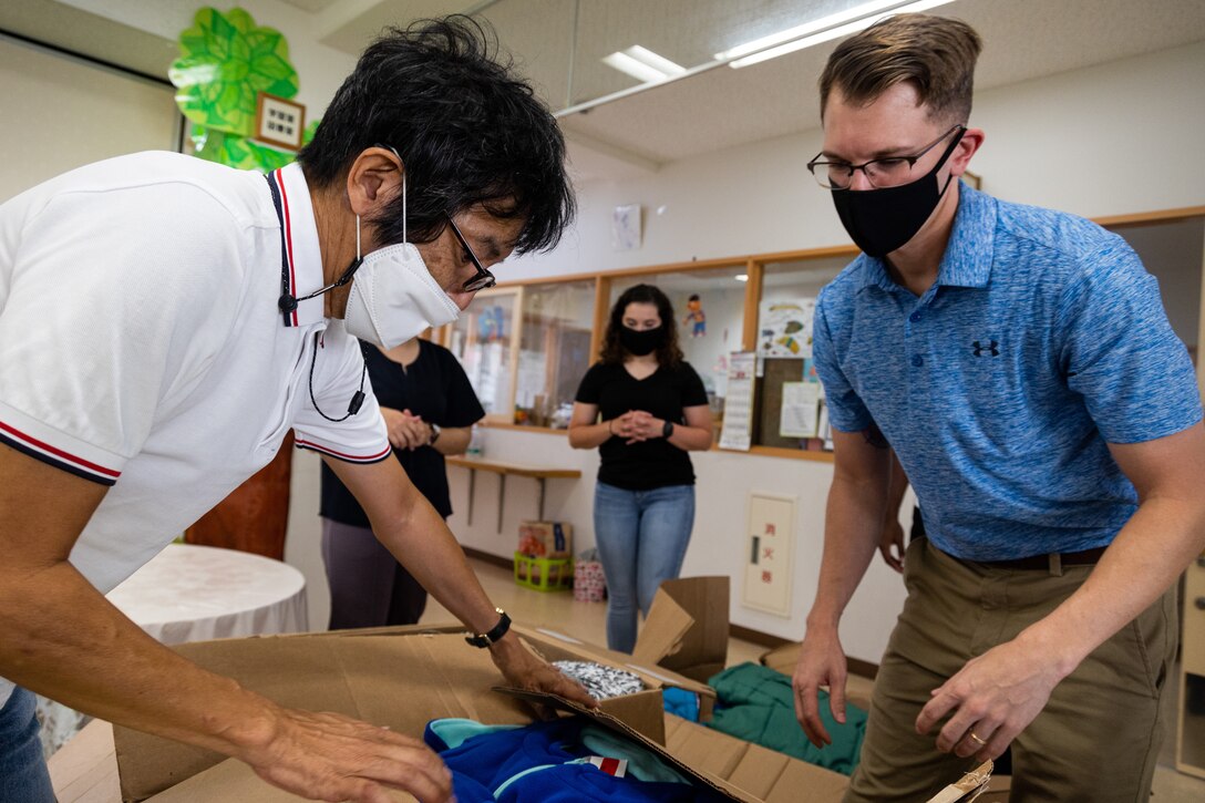 Ichiro Umehara, left, a community relations specialist for Camp Courtney, helps unpack donated clothes with U.S. Navy Lt. Youree Posey, chaplain for Headquarters Battalion, 3rd Marine Division, at the Rainbow Heights Single Mothers Shelter in Okinawa City, Okinawa, Japan, Oct. 4, 2021. Rainbow Heights Single Mothers Shelter is an Okinawa City mother and child-life support facility, and an emergency shelter for mothers and their children. (U.S. Marine Corps photo by Lance Cpl. Faith Rose)
