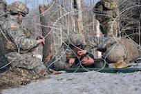 Engineer Soldiers assemble a barbed wire obstacle